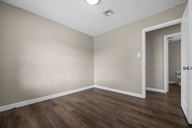 spare room featuring dark hardwood / wood-style flooring and a textured ceiling