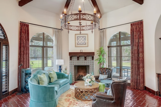 sitting room featuring a tile fireplace, a high ceiling, and beamed ceiling