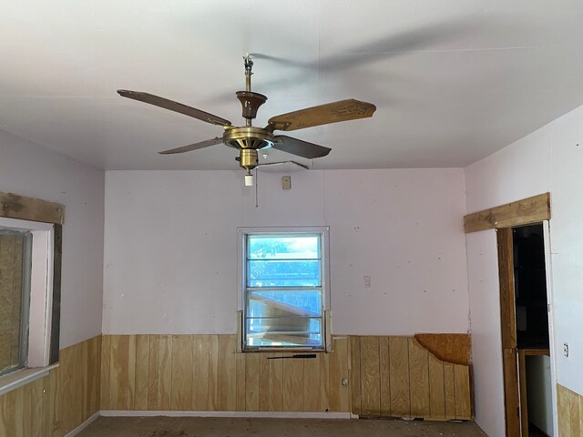 spare room with wooden walls and ceiling fan