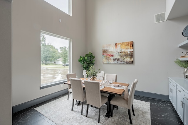 dining space featuring a high ceiling and plenty of natural light