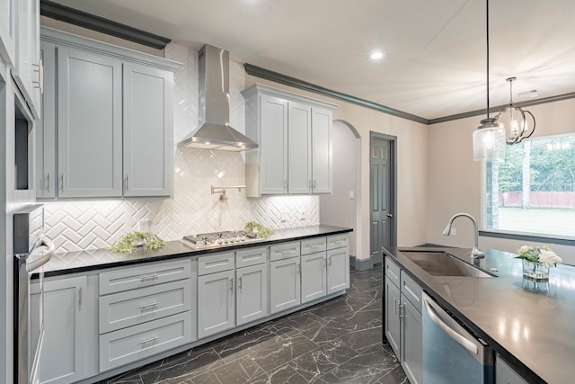 kitchen with hanging light fixtures, sink, tasteful backsplash, wall chimney exhaust hood, and appliances with stainless steel finishes