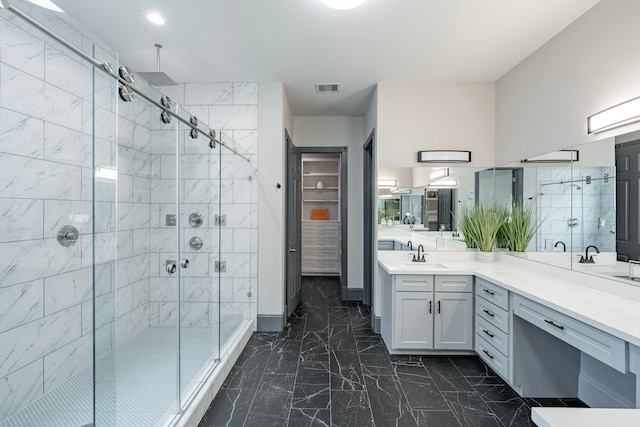 bathroom featuring a shower with door and vanity