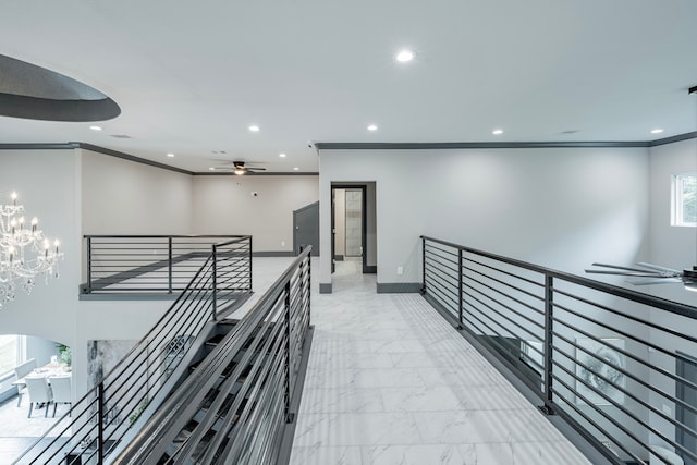 hallway with a notable chandelier and crown molding