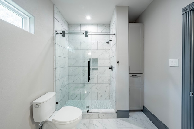 bathroom featuring a shower with shower door and toilet