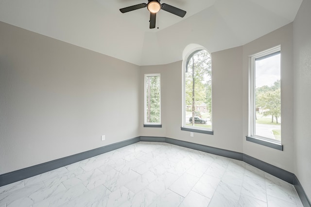 spare room featuring ceiling fan, vaulted ceiling, and a healthy amount of sunlight