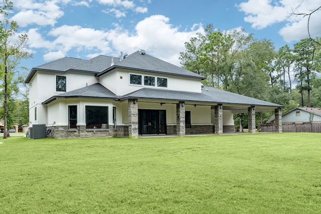 rear view of property featuring ceiling fan, a yard, and central AC