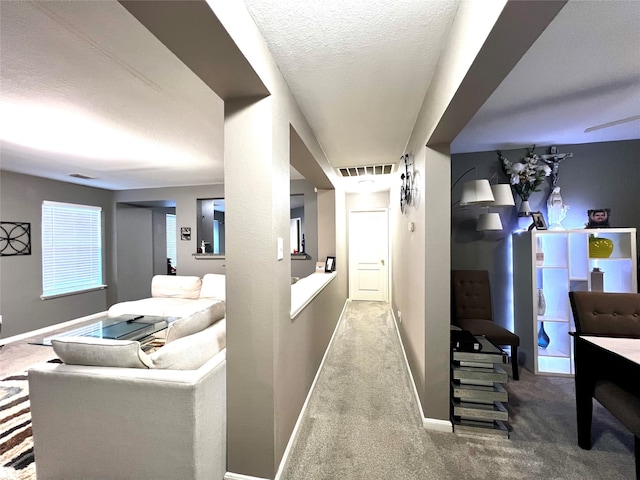 hallway featuring a textured ceiling and carpet