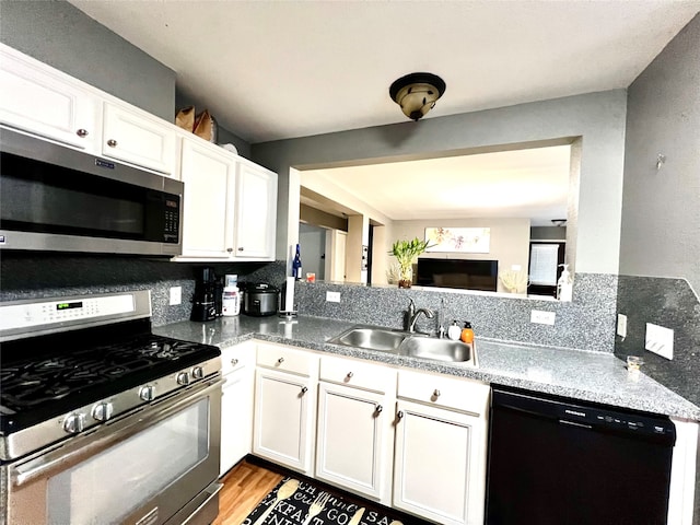 kitchen with light hardwood / wood-style flooring, sink, appliances with stainless steel finishes, and white cabinetry