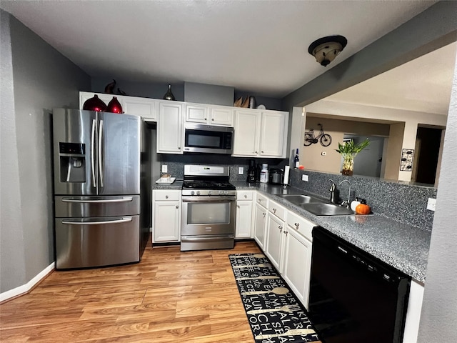 kitchen featuring white cabinets, appliances with stainless steel finishes, sink, and light hardwood / wood-style flooring