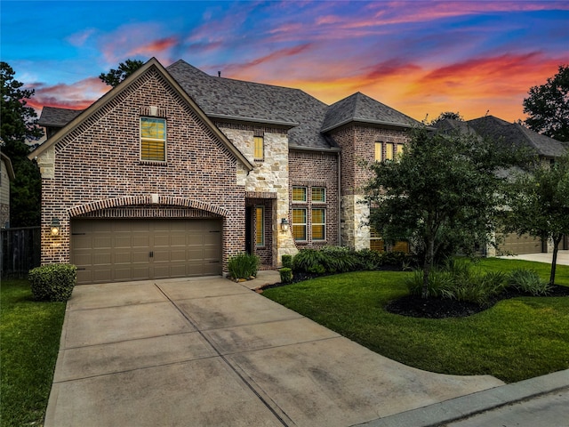 view of front of property featuring a garage and a yard