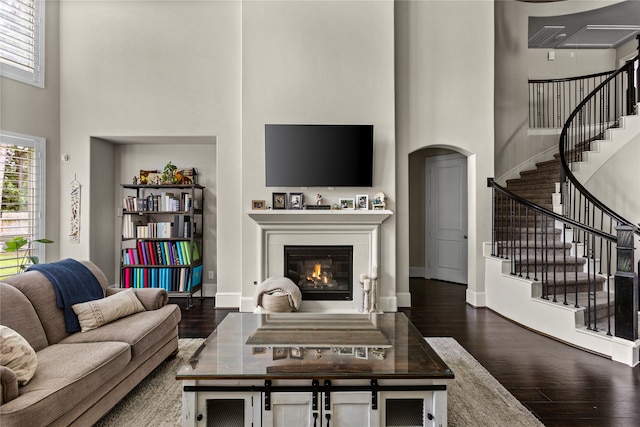 living room with a high ceiling and dark hardwood / wood-style floors