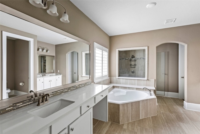 full bathroom featuring plus walk in shower, wood-type flooring, toilet, and vanity