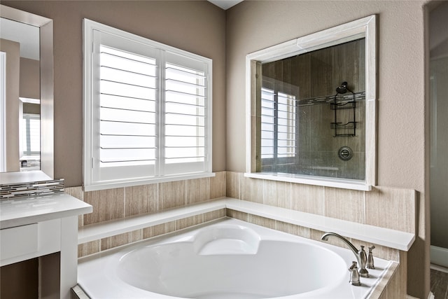 bathroom featuring shower with separate bathtub, plenty of natural light, and vanity