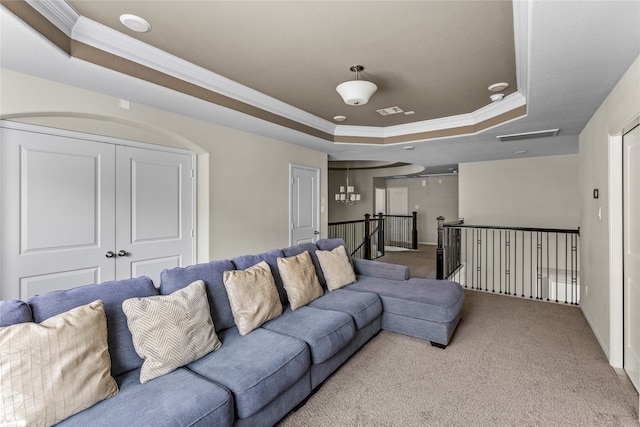 carpeted living room featuring crown molding, a raised ceiling, and an inviting chandelier