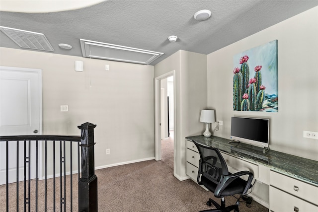 carpeted office space featuring built in desk and a textured ceiling