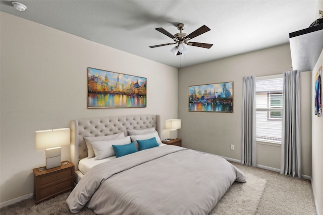 bedroom featuring a textured ceiling, ceiling fan, and light carpet