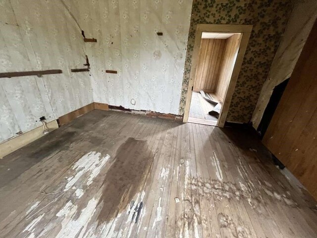 300 E Curtis St, Quanah, TX 79252 - spare room with hardwood / wood-style flooring, wallpapered walls, and baseboards