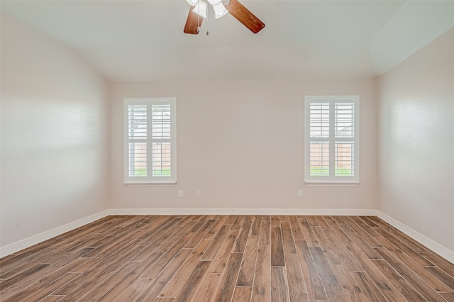 spare room with a healthy amount of sunlight, wood-type flooring, and ceiling fan