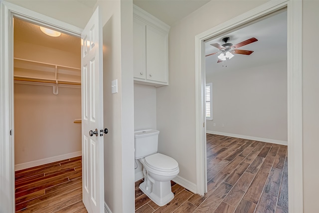 bathroom featuring wood-type flooring, toilet, and ceiling fan