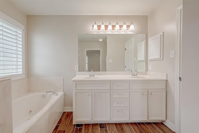 8705 Rowen Ct, Needville, TX 77461 - bathroom featuring wood finished floors, a whirlpool tub, and a sink