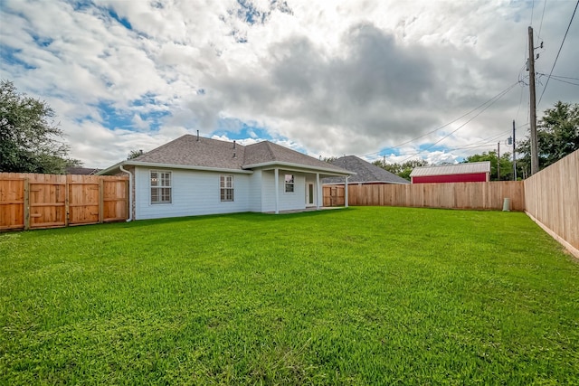 8705 Rowen Ct, Needville, TX 77461 - rear view of house with a fenced backyard, a yard, and roof with shingles