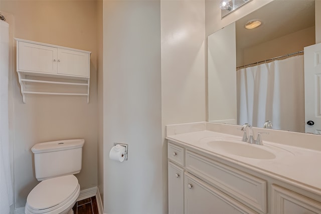 bathroom with toilet, hardwood / wood-style flooring, and vanity