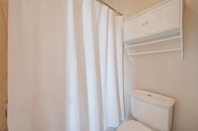 bathroom with toilet and curtained shower