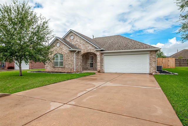 8705 Rowen Ct, Needville, TX 77461 - ranch-style house with concrete driveway, an attached garage, fence, brick siding, and a front lawn
