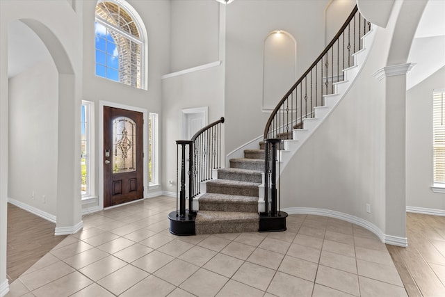 entrance foyer with light wood-type flooring and a towering ceiling