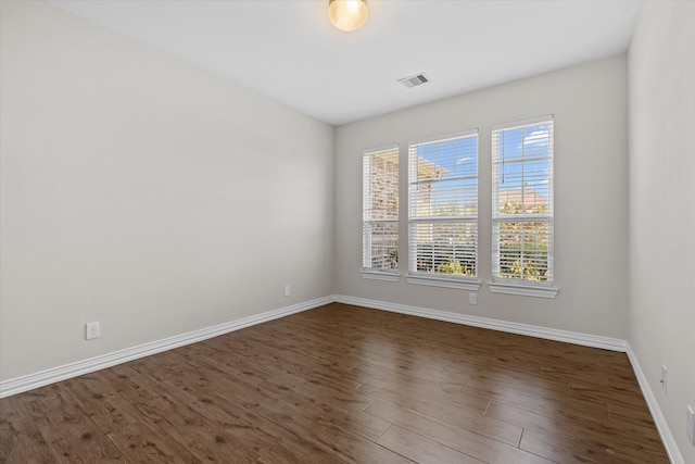 unfurnished room with dark hardwood / wood-style flooring