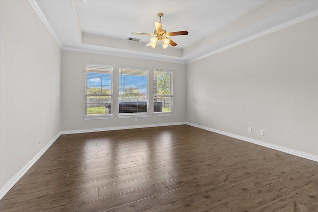 spare room with a raised ceiling, crown molding, dark hardwood / wood-style floors, and ceiling fan