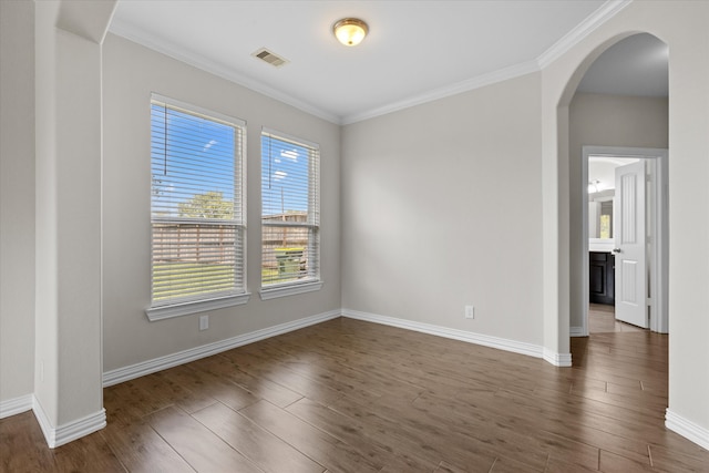 spare room with ornamental molding and dark wood-type flooring