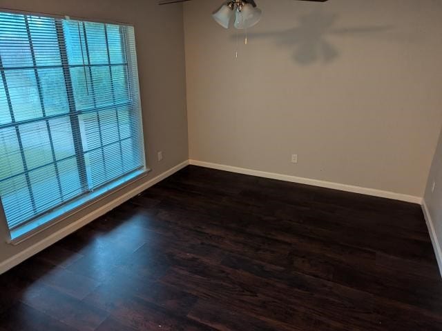 unfurnished room with ceiling fan and dark wood-type flooring