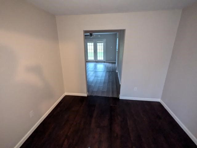 empty room with dark hardwood / wood-style floors, ceiling fan, and french doors