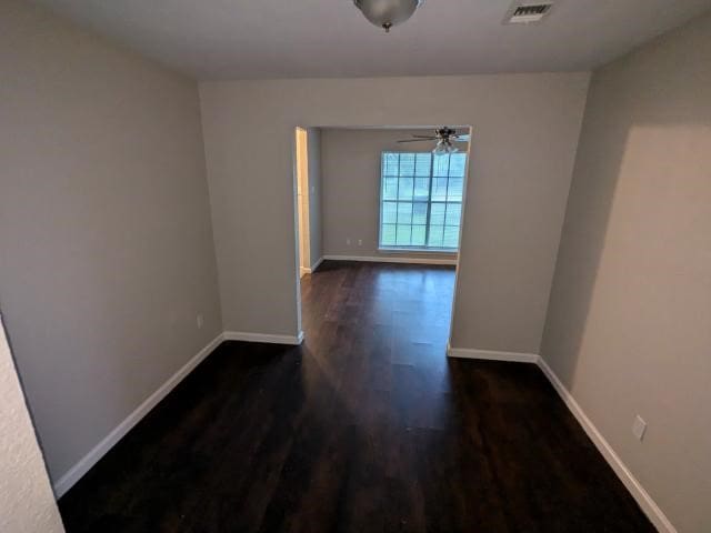 unfurnished room featuring ceiling fan and dark wood-type flooring