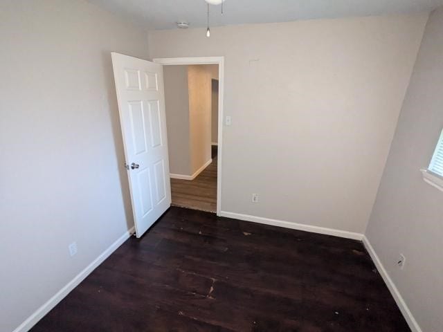 unfurnished room with ceiling fan and dark wood-type flooring