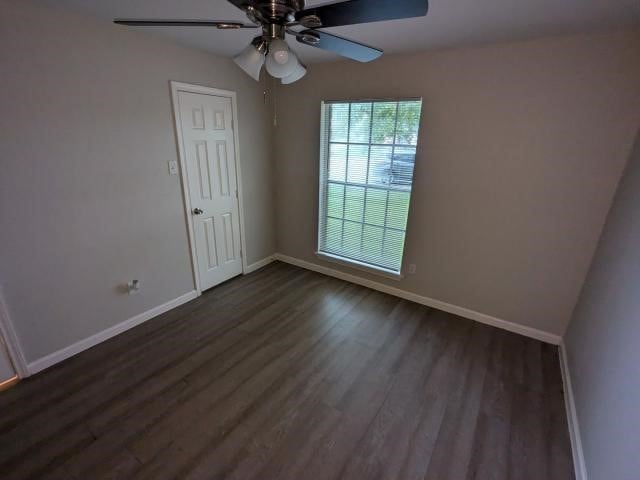 unfurnished room featuring dark hardwood / wood-style floors, ceiling fan, and vaulted ceiling