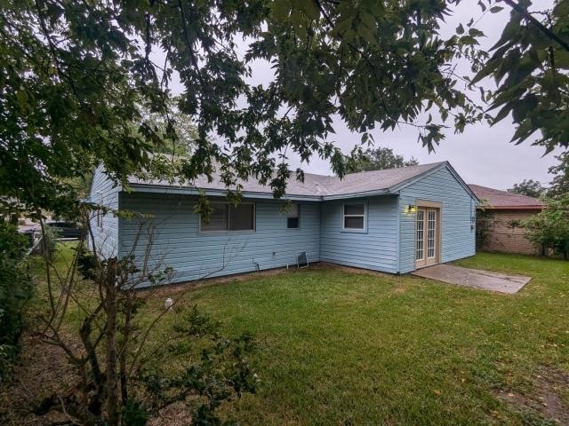 rear view of property featuring a yard