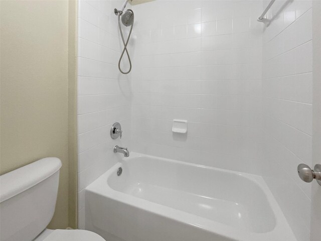 bathroom featuring toilet and tiled shower / bath combo