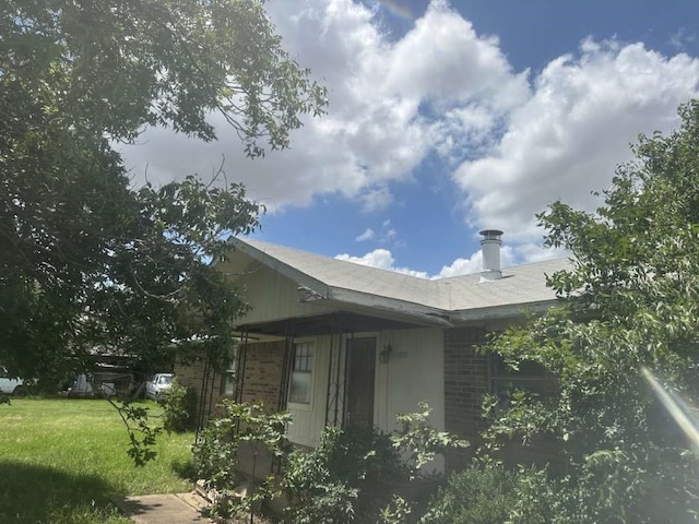 view of side of home with a yard