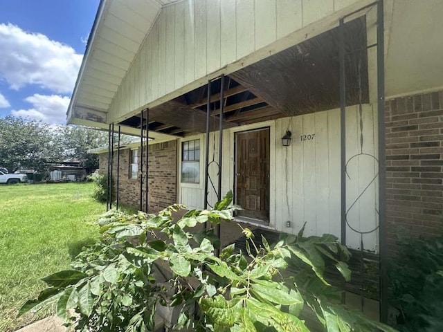 property entrance featuring a lawn