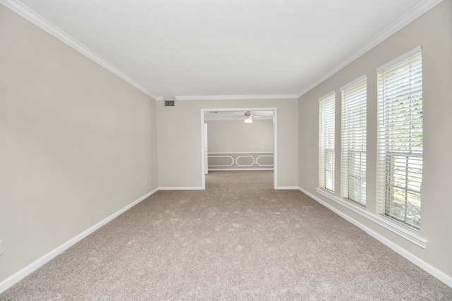 carpeted empty room featuring ceiling fan, crown molding, and a healthy amount of sunlight