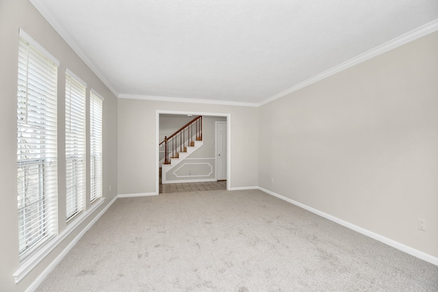 unfurnished room with ornamental molding and carpet flooring