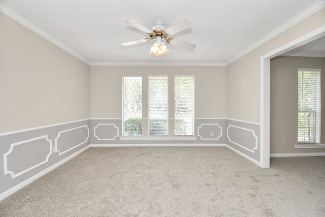 carpeted empty room featuring ornamental molding, a healthy amount of sunlight, and ceiling fan