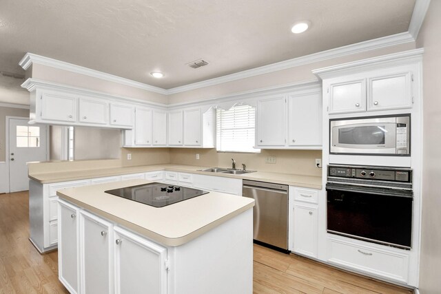 kitchen featuring light wood-type flooring, a kitchen island, sink, black appliances, and white cabinetry