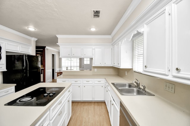 kitchen with black appliances, sink, a wealth of natural light, and white cabinetry