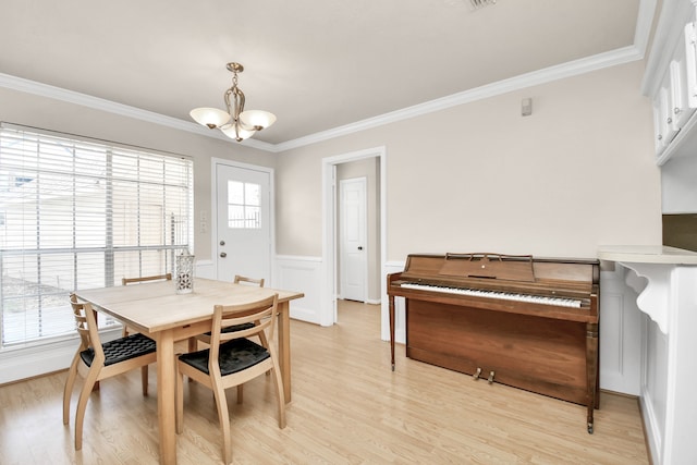 dining room featuring crown molding, light hardwood / wood-style floors, and a chandelier