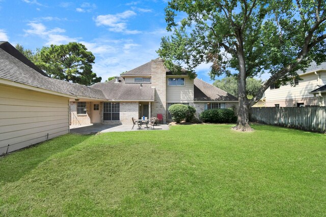 rear view of property featuring a yard and a patio