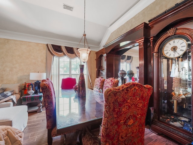 dining space with wood-type flooring, vaulted ceiling, ornamental molding, and ornate columns