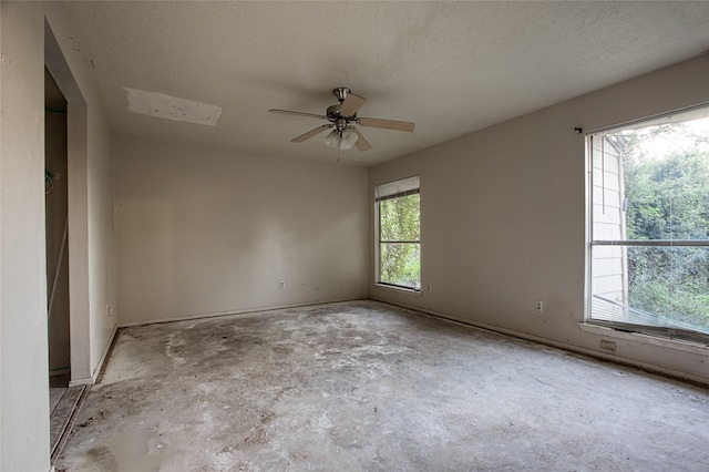 spare room with ceiling fan, a wealth of natural light, and a textured ceiling